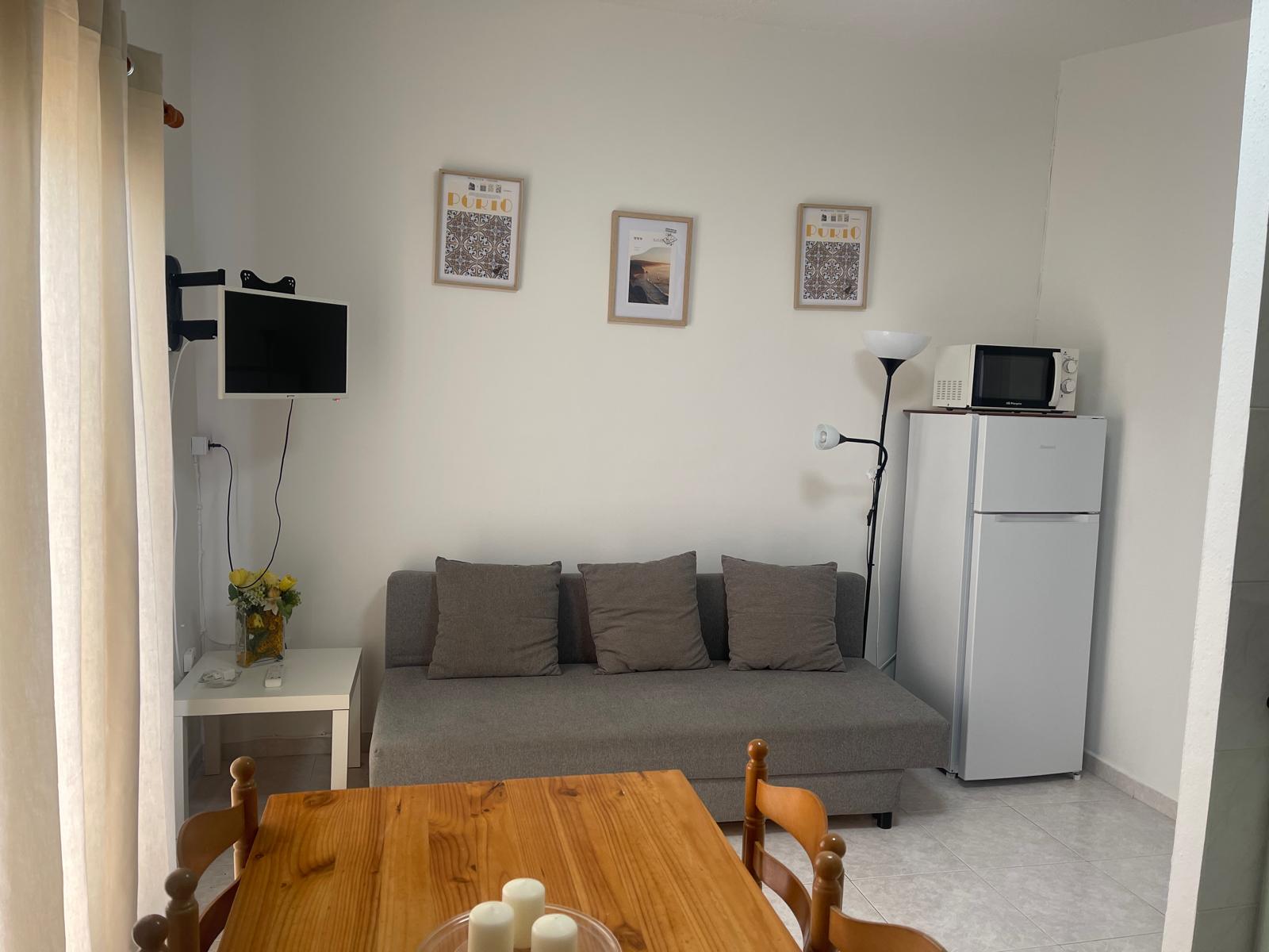 Salón con sofá, TV y zona de estar